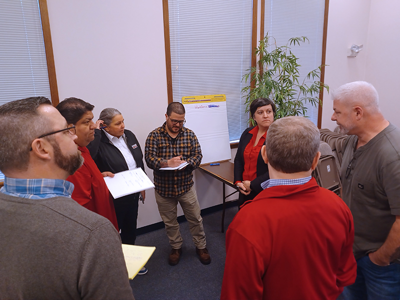 Negotiation team members meet with staff to discuss workforce